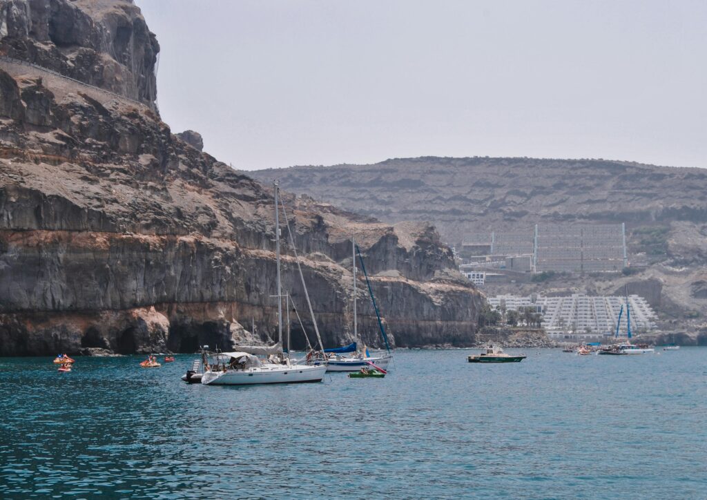 pexels-photo-9091399-9091399 Sailboats and catamarans in the rocky bay of Las Palmas, Spain, offering a beautiful seaside view.