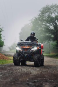 A person driving an ATV through a foggy forest trail, showcasing adventure and exploration.