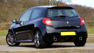 Black Renault Clio RS hot hatchback car parked outdoors surrounded by nature.